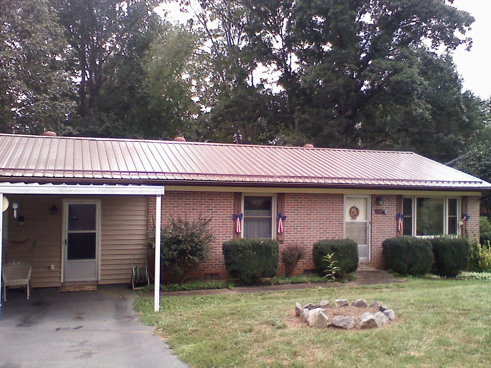 Bronze metal roof and carport on a brick ranch home — Roof Repair work by our crew in Columbus